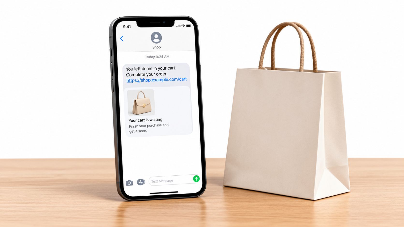 A smartphone displaying an abandoned cart text message notification next to a minimalist paper shopping bag.